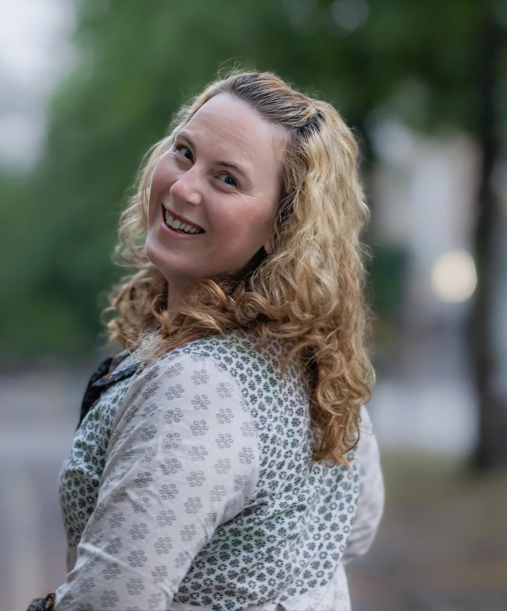 Kristine Sveum smiling over her shoulder, photographed outdoors